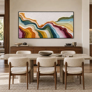 Horizontal curved-band painting above a wood sideboard behind a pale dining table.