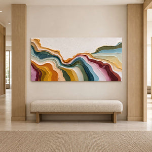 Colorful textured artwork above an upholstered bench between light wood wall panels.