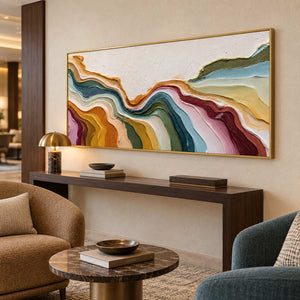 Wide ribbon painting above a dark console between warm brown and teal lounge chairs.