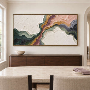Flowing green, blush, ochre and charcoal bands through white texture in a gold frame, displayed above a dining table.