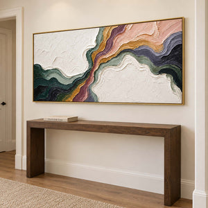 Flowing green, blush, ochre and charcoal bands through white texture in a gold frame, displayed in a hallway.