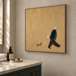 Ochre painting of a flower-carrying walker and a small brown dog in a brown wood frame beside a bathroom vanity.