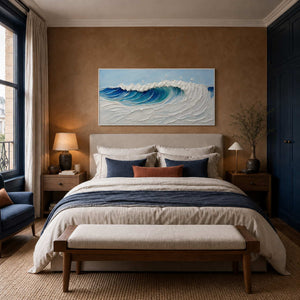 Textured ocean wall art displayed above a calm upholstered bed.