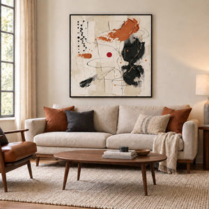 Dancing on a Whim in a black frame above a cream sofa with rust and charcoal cushions.
