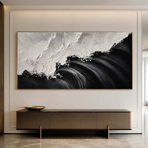 Gold framed monochrome coastal artwork above a long console in a bright hallway.