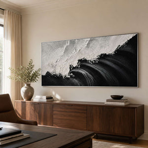 Silver framed wave painting with sweeping dark curves above a walnut office cabinet.