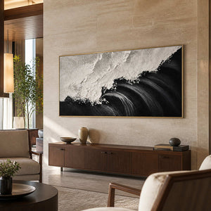 Gold framed panoramic coastal painting with rolling waves above a hotel lobby console.
