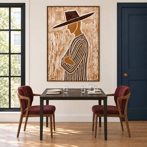 Tilted-hat portrait over a dark dining table and burgundy chairs beside a navy door.