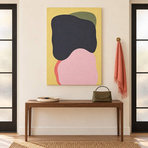 Yellow abstract painting with charcoal, blush, olive, and coral shapes without an outer frame in an entryway.