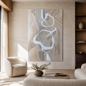 Frameless white ribbon abstract artwork above neutral lounge seating in a sunlit living room.