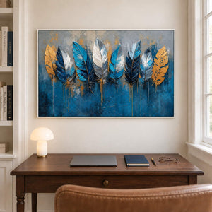 Blue, white and gold feathers against a deep blue and gray background in a white frame, displayed in a home office.