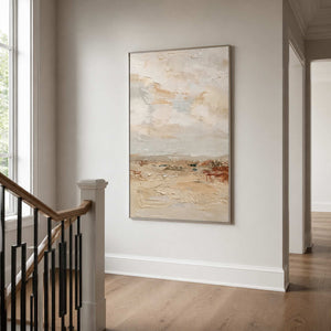 Silver framed cream landscape painting displayed on a bright staircase landing.