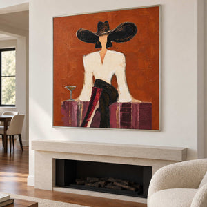 Hat portrait above a pale fireplace beside a curved armchair.