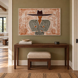 Effortless Poise in a white frame above a dark wood hallway console and a cream upholstered stool.
