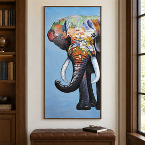 Artwork showing a front-facing elephant with an upcurled trunk, pale tusks and colored blocks on blue above a bench beside bookshelves, with a brown wood-look frame.