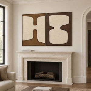 Two panels of complementary ivory organic forms on brown grounds in black frames, displayed above a fireplace.