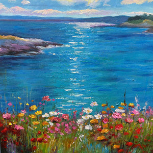 Detail of the bright reflection on blue water above pink, white, red and yellow foreground flowers.