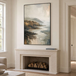 A rocky coast receding into soft gray mist in a black frame, displayed above a fireplace.