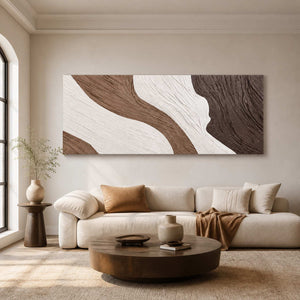 Long textured abstract wall art above a cream sofa and round wooden table.