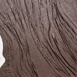 Close-up of fine raised grooves curving through dark brown textured abstract wall art.
