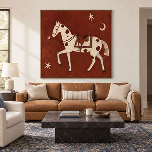 Rust-red horse artwork above a tan sofa and dark square coffee table.