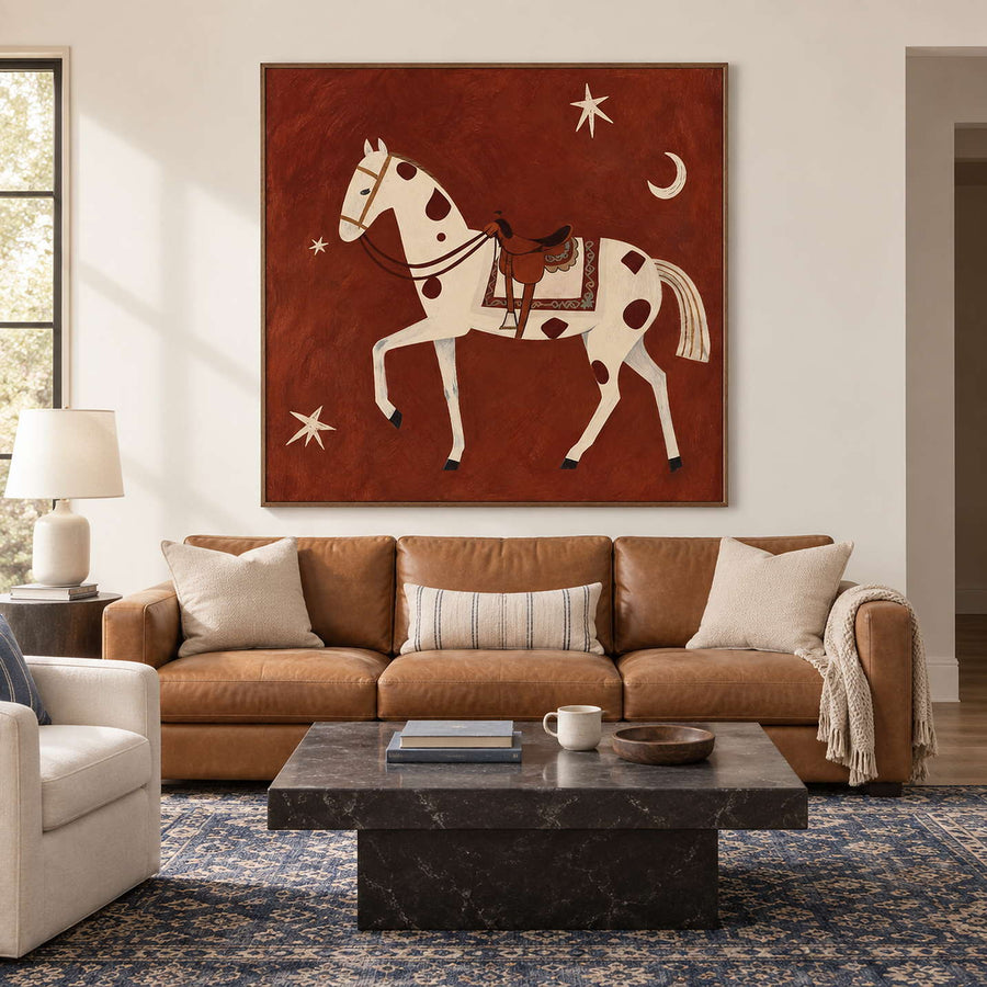 Rust-red horse artwork above a tan sofa and dark square coffee table.