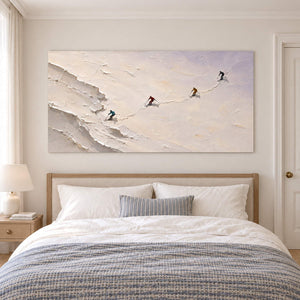 Four skiers crossing an open ivory-white slope without an outer frame, displayed above a bed.