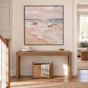 Free as the Sea in a wood frame above a hallway console and woven basket beside a staircase.