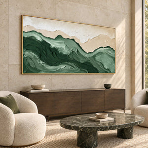 Free to Wander in a gold frame above a dark sideboard beside rounded cream chairs and a dark stone table in a lobby.