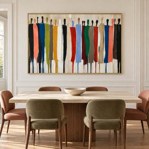 A row of painted figures above a wood dining table with green and muted pink chairs.