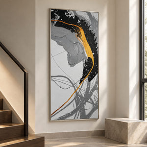 Artwork showing broad black and gray brush arcs crossed by a gold-colored line and white flecks beside a staircase, with a silver-colored frame.