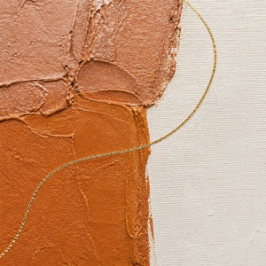 Close-up of raised clay paint and a looping metallic gold line.