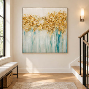 Hand-painted gold blossoms above soft aqua and ivory drips on canvas, displayed beside a staircase in a silver frame.