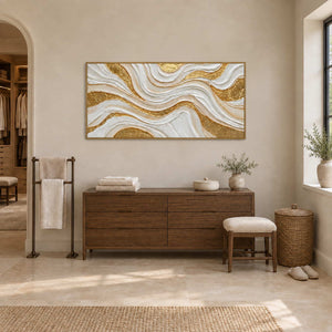 Golden Years in a gold frame above a wood cabinet with folded towels and a stool in a bathroom dry area.