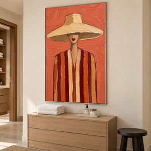 Warm portrait above a wooden dresser holding folded towels and a small tray.