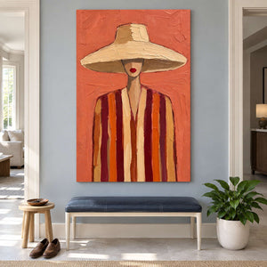 Hat and striped-clothing artwork above a navy entryway bench beside a leafy plant.