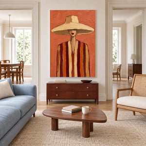 Coral hat portrait above a dark chest in a living room with a blue sofa.