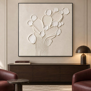 Sculptural warm white petals and leaves raised from a monochrome canvas, displayed in a lounge in a black frame.