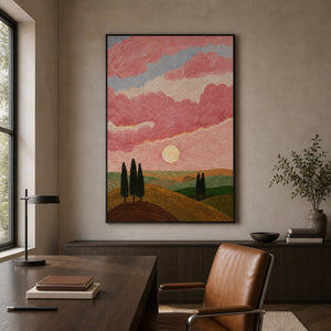 Black framed vertical landscape with pink clouds displayed beside a home study desk.