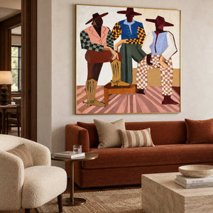 Broad-hatted figures artwork above a rust-colored sofa with neutral and striped cushions.