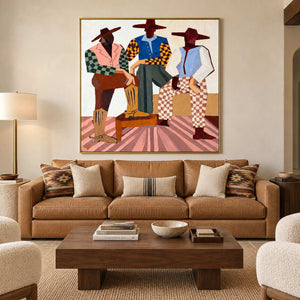 Three-figure artwork above a tan leather sofa with striped and patterned cushions.