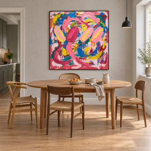 In Full Swing in a black frame above an oval wood dining table surrounded by natural wood chairs.
