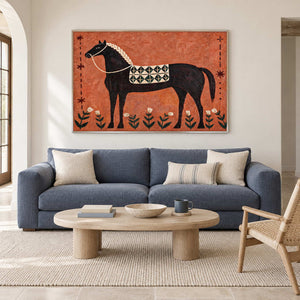 Orange horse painting above a blue sofa and oval wooden coffee table.
