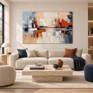 Cream and orange abstract artwork above a pale sofa with navy and rust-colored cushions.