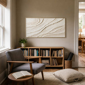 Neutral textured wall art displayed in a quiet reading nook.