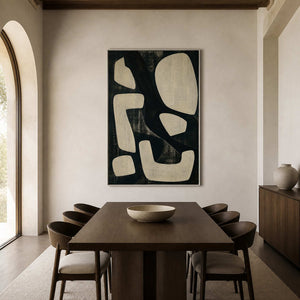 Black and cream abstract wall art in a dining room with a silver frame.