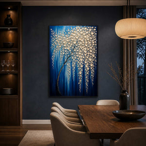 Ivory botanical artwork glowing against a deep blue dining room wall.