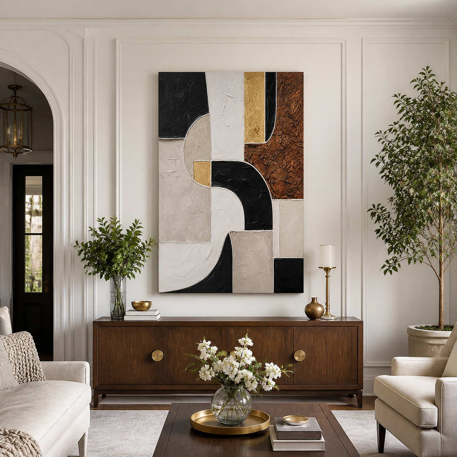 Frameless geometric artwork above a wooden sideboard between cream living room seats.