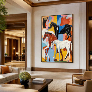 Black framed equestrian artwork showing three horses against vivid colors in a hotel lobby.