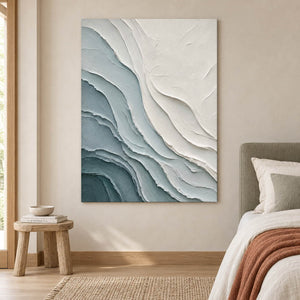Layered blue-gray and chalk-white coastal relief painting without an outer frame in a bedroom.